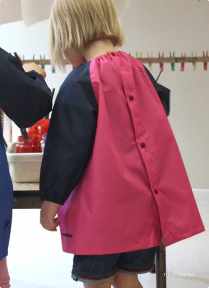 girl painting wearing muddlarks pink smock